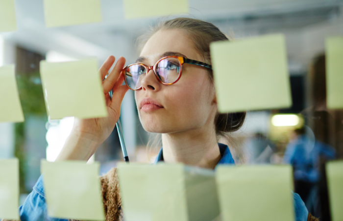 Kobieta patrząca na przyklejone kartki post-it